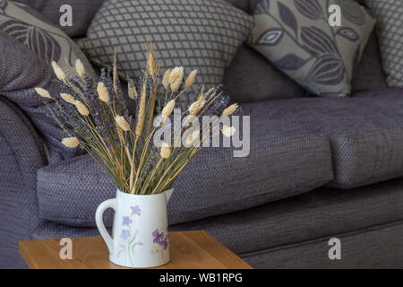 Getrocknetem Lavendel und getrockneten Gräsern in einem Krug in einem modernen Ambiente. Stockfoto