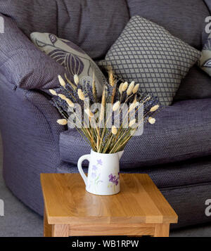 Getrocknetem Lavendel und getrockneten Gräsern in einem Krug in einem modernen Ambiente. Stockfoto