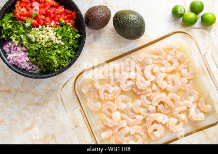 Ceviche, auch als cebiche, seviche und sebiche bekannt. Die Shrimps Ceviche und die Zutaten zum Kochen dieser Lateinamerikanischen Meeresfrüchte Teller benötigt Stockfoto