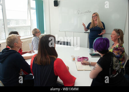 Frauen um am Tisch in einem Geschäft Präsentation oder Konferenz Stockfoto