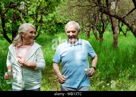 Senior glücklich Frau an Mann mit grauem Haar, die während der Ausführung im Green Park Stockfoto