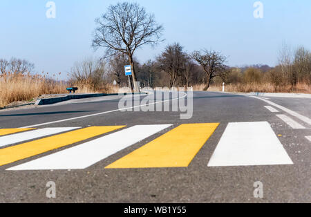 Fußgängerüberweg Streifen, gelbe und weiße Linien auf dem Asphalt Stockfoto