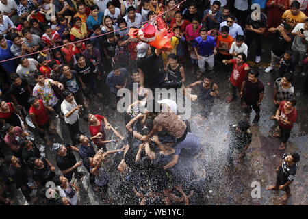 Kathmandu, Nepal. 23 Aug, 2019. Eine nepalesische Youngster bricht einen Tontopf während Krishnas Janmashtami Festival, das die Geburt des hinduistischen Gottes Lord Krishna, in Samakhusi, Kathmandu, Nepal Markierungen am 23 August, 2019. Die Teilnehmer erhalten ein Preisgeld ausnutzen, indem er eine menschliche Pyramide groß genug, um das top Person den Topf zu erreichen und den Inhalt nach zu brechen. (Foto durch Subash Shrestha/Pacific Press) Quelle: Pacific Press Agency/Alamy leben Nachrichten Stockfoto