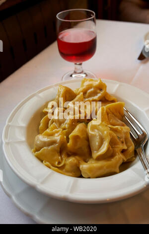 Platte von Tortellini und Glas Rotwein Stockfoto