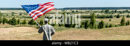 Panorama-aufnahme des militärischen Mann stand in der Nähe der Bäume und die amerikanische Flagge Stockfoto