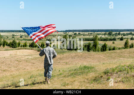 Militärische Mann in Uniform stehen auf Gras und die amerikanische Flagge Stockfoto