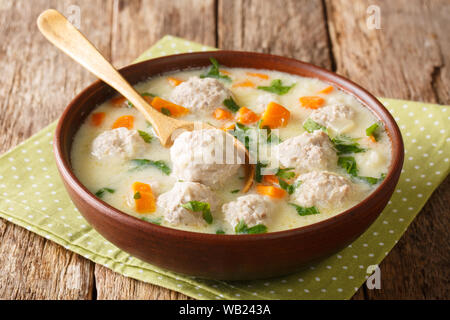 Frische dicke Suppe mit Fleischbällchen, Joghurt, Reis und Gemüse close-up in einer Schüssel auf dem Tisch. Horizontale Stockfoto