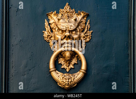 Chinesischer Dämon golden door handle-Klopfer in einem grünen Holztür Stockfoto