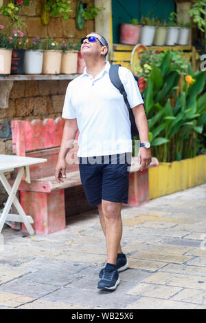 Senior touristische Männlich Zu Fuß mit Rucksack in der Stadt. Portrait von Business zuversichtlich älteren Reisenden Mann auf Urlaub. Reise und Tourismus Konzept. Stockfoto