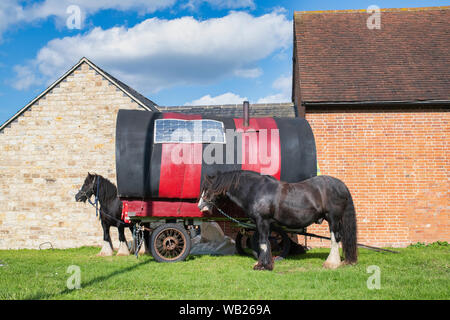 Gypsy Caravan und Pferde an der Seite der Straße vor den Gebäuden in der Nähe von Lighthorne Heide, Warwickshire, England Stockfoto