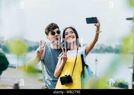 Schöner Mann und die asiatische Frau, Frieden Zeichen und unter selfie Stockfoto