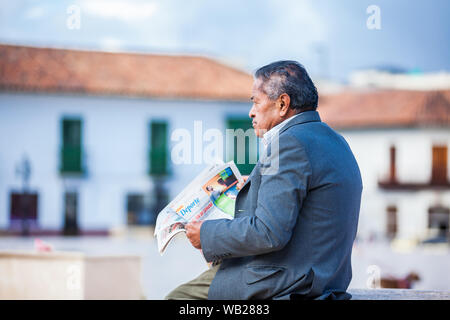 TUNJA, KOLUMBIEN - AUGUST, 2019: Ältere Menschen eine Zeitung lesen an der Bolivar Square in Tunja Stadt Stockfoto