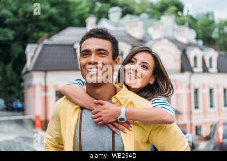 Glücklich umarmten schönen gemischten Rennen Mann in der Nähe von Gebäude Stockfoto