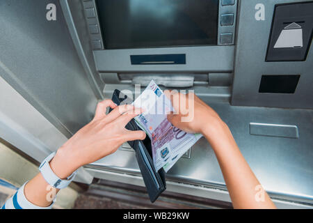 Blick von oben auf die Frau Geld im Portemonnaie in der Nähe von Geldautomaten Stockfoto