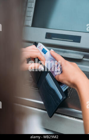 Selektiver Fokus der Frau Geld im Portemonnaie in der Nähe von Geldautomaten Stockfoto