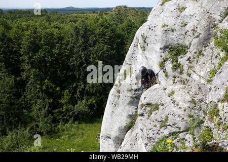 Kletterer auf einem Felsen in der Gegend von den Ruinen des Schlosses in Olsztyn, Polen. Krakow-Czestochowa Hochland, die Polnische Jurassic Highland oder Polnische Jura Stockfoto