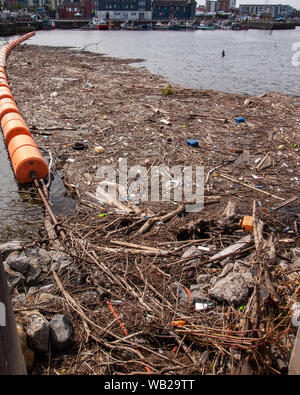 Floating Barriere voller Müll, Holz, Kunststoff Flaschen und Treibgut in der Nähe der Mündung des Flusses Tawe in Swansea, Wales, UK. Stockfoto