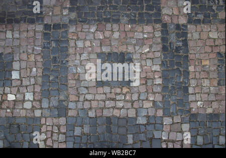 Pflasterung Brücken mit Granit Fliesen von verschiedenen geometrischen Formen. Buntes Mosaik Quadrate aus Granit Fliesen. Pflaster in der Altstadt. Textur. Mosaik Stockfoto