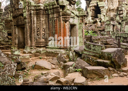 Geschnitzte Sandstein bas-relief Apsaras (himmlische Jungfrauen) und geschnitzten Stein Fenster Balken beim Ta Prohm Tempel, Siem Reap, Kambodscha. Stockfoto