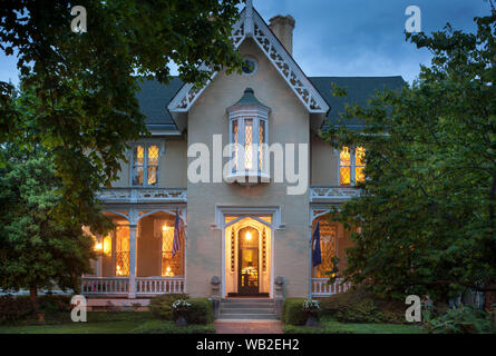 Fassade des Hauses mit Fahnen und Garten im Sommer bei Nacht, American Gothic Revival Stil, Inn at Woodhaven, Louisville, Kentucky, USA Stockfoto