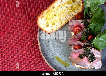 Beef Sandwich mit rucula, Kirschtomaten und Pesto. Stockfoto