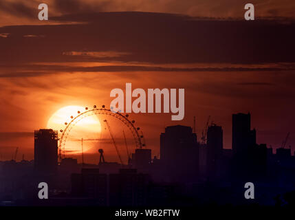 London, Großbritannien. 23 August, 2019. UK Wetter: ein dramatischer Sonnenuntergang fährt hinter dem London Eye Riesenrad von Greenwich Park gesehen. Credit: Guy Corbishley/Alamy leben Nachrichten Stockfoto