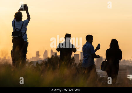 London, Großbritannien. 23 August, 2019. UK Wetter: Einheimische, Touristen und einem warmen Abend Sonnenuntergang von der Oberseite der Greenwich Park. Credit: Guy Corbishley/Alamy leben Nachrichten Stockfoto