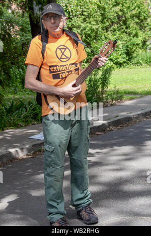 Ein Aktivist aus der Gruppe Aussterben Rebellion steht eine guitalele während eines Protestes. Stockfoto