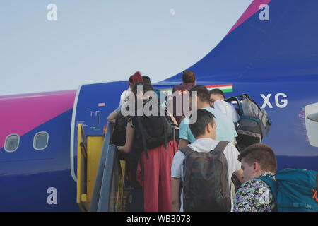 Die Menschen in der Schlange in eine WizzAir flugzeug zu erhalten Stockfoto