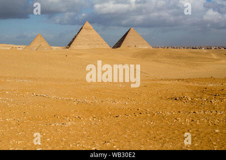 Drei Pyramiden (von rechts nach links) Khufu, Khafre und Menkuare in Ägypten am Vormittag bewölkt Tag, der Hintergrund ist die Stadt von Gizeh. Die drei Kleinen Stockfoto