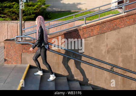 Junge Frau mit rosa Zöpfe zu Fuß die Treppen hoch in Minsk, Belarus. Stockfoto