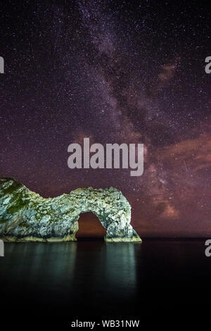 Durdle Door, Lulworth, Dorset, Großbritannien. 23. August 2019. UK Wetter: Die Milchstraße erstrahlt in den klaren Nachthimmel über dem Kalkstein sea Arch von Durdle Door auf der Dorset Jurassic Coast. Foto: Graham Jagd-/Alamy leben Nachrichten Stockfoto