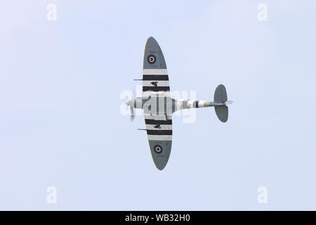 Eine Spitfire Pässe Overhead seine elliptische Flügel zeigen. Die Streifen waren auf alliierte Flugzeuge, um Sie von feindlichen Flugzeugen auf D zu unterscheiden - Tag setzen. Stockfoto
