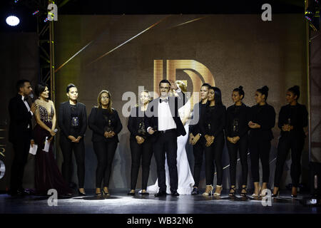 Valencia, Carabobo, Venezuela. 22 Aug, 2019. August 23, 2019. Fashion Designer Daniel Fabregas (C) mit seiner Arbeit Team grüßt die Öffentlichkeit während der Endrunde der Fashion Show'' zusammen kommen'' von Fashion Designer Daniel Fabregas, der unter seinen 150 Modelle Menschen mit Eigenschaften außerhalb der Normen des internationalen Mode enthalten und der Öffentlichkeit präsentieren konnte die Mischung zwischen herkömmlichen Modellen mit Transsexuelle, groß, mit Down Syndrom, im Rollstuhl und Krücken unterstützt, abgesehen von der Vielfalt der Haut Farben und Rassen. Unter anderem. Die Parade fand an der Hes Stockfoto