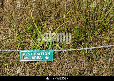 Natürliche wiese Wiederherstellung des Lebensraums in Grün und Weiß Hinweise und Informationen Zeichen auf dem Boden mit Seil. beschädigte Gras von ging weiter zu schützen. Stockfoto