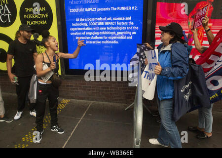 August 23, 2019: Eine Frau wird während einer Demonstration gegen Greyhound Corporation und Eis (Einreise Zoll- und Durchsetzung) und konfrontieren, anti-Demonstranten und Trump Unterstützer am Port Authority Bus Terminal in der 42. und 8. Avenue in New York, New York. Über 100 Aktivistinnen aus einer Koalition von Gruppen einschließlich Feuer (für ausländische Flüchtlinge überall Kämpfen) Greyhound, EIS Agenten ihre Busse 'suchen für Migranten zu protestiert", sagten Beamte. Credit: Brian Zweig Preis/ZUMA Draht/Alamy leben Nachrichten Stockfoto