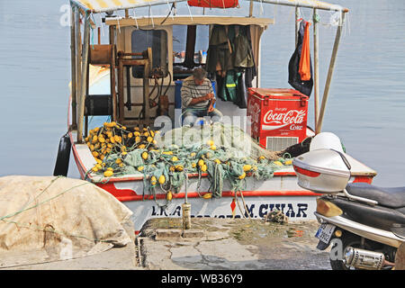 Fischer Flicken der Netze auf seinem Boot in Kusadasi, Türkei Stockfoto