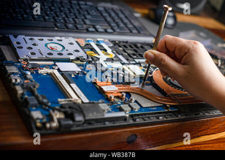 Techniker die Reparatur defekter Laptop Notebook Computer mit Schraubendreher Stockfoto