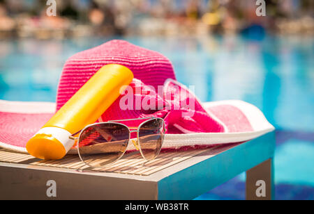 Flaschen Sonnencreme mit Sonnenbrille und Hut auf Tabelle Stockfoto