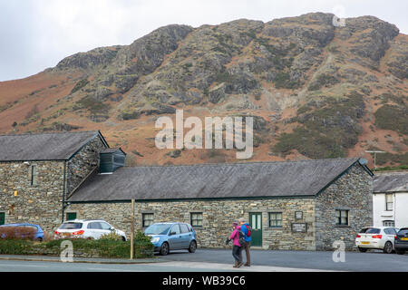 Wanderer zu Fuß durch Coniston Dorf im Lake District, Cumbria, England an einem Wintertag Stockfoto