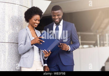 Fröhliche Geschäftsmann und Geschäftsfrau Arbeiten im Stehen im Freien Stockfoto