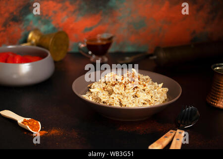 Traditionelle für türkische, griechische und iranische Küche, ein Gericht namens Keskek. Mit eingelegten roten Pfeffer, Butter und Paprikapulver serviert. Ansicht von vorn Stockfoto