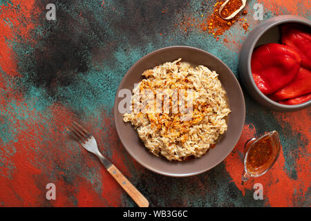 Traditionelle für türkische, griechische und iranische Küche, ein Gericht namens Keskek. Mit eingelegten roten Pfeffer, Butter und Paprikapulver serviert. Ansicht von oben Stockfoto