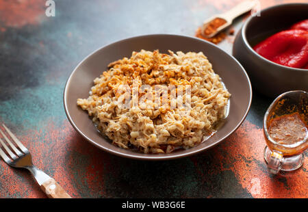 Traditionelle für türkische, griechische und iranische Küche, ein Gericht namens Keskek. Mit eingelegten roten Pfeffer, Butter und Paprikapulver serviert. Close-up Stockfoto