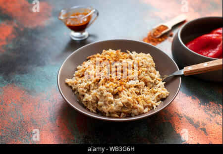Traditionelle für türkische, griechische und iranische Küche, ein Gericht namens Keskek. Mit eingelegten roten Pfeffer, Butter und Paprikapulver serviert. Close-up Stockfoto