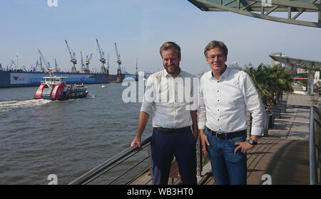 23. August 2019, Hamburg: Der Fraktionsvorsitzende von Bündnis 90/Die Grünen, Anjes Tjarks (l), und Dirk Kienscherf, Fraktionsvorsitzende der SPD, stehen an den Landungsbrücken. Sozialdemokraten und Grüne in Hamburg und Rotterdam wollen die Zusammenarbeit zwischen den beiden Hafenstädte bei der Verringerung der Luftverschmutzung durch Seeschiffe abgegeben zu fördern. Foto: Martin Fischer/dpa Stockfoto