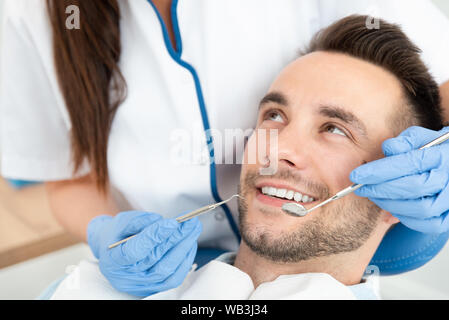 Mann, der Zähne Zahnärzte untersucht. Übersicht von Karies Vorbeugung Stockfoto