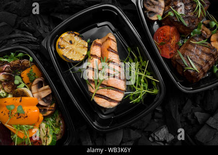 Eingestellt von gegrilltem Gemüse, Fisch und Fleisch in Lieferkartons Stockfoto