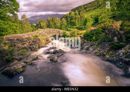Ashness Brücke ist ein Beispiel für einen packesel Brücke, mit Blick nach Norden, um Derwentwater, Whinlatter und Skiddaw. Stockfoto