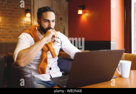 Unternehmer/in und tut seine Arbeit im Cafe Stockfoto